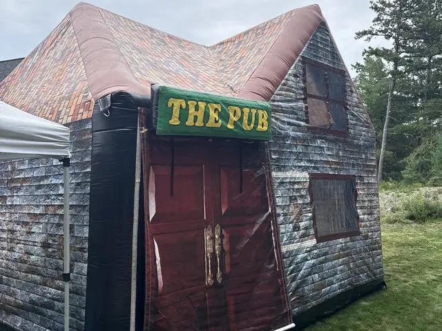 The Aer set up on grass, its doors open and pub sign above the entrance